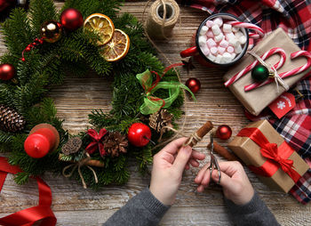 Cropped hand of woman decorating christmas tree