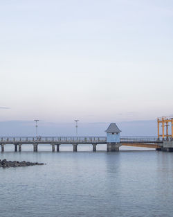 Pier over sea against sky during sunset