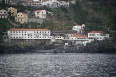 Buildings by river in town