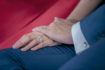 Midsection of couple holding hands