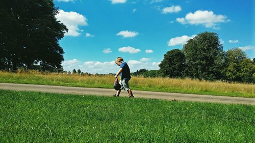 Full length of man riding bicycle on road