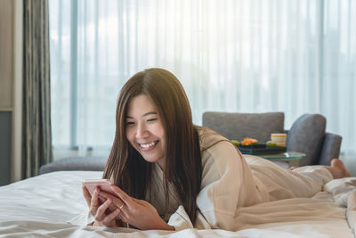 Portrait of smiling young woman using mobile phone