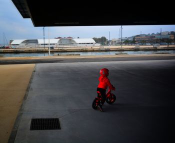 Boy riding motorcycle on road against sky