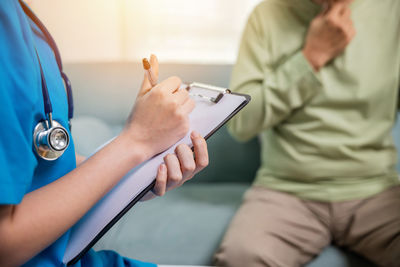 Midsection of doctor examining patient in hospital