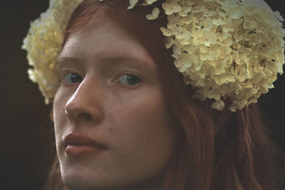 Close-up portrait of young woman wearing flowers on hair