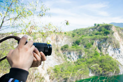 Midsection of man photographing camera on mobile phone