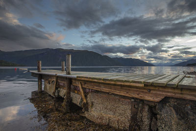 An empty dock at sunset on a fjord in norway