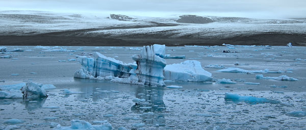 Scenic view of glacier with mountain range in background