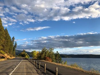 Road by lake against sky