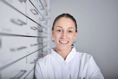 Portrait of smiling young woman wearing lab coat