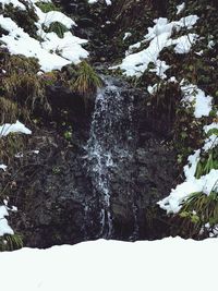 Scenic view of waterfall in forest during winter