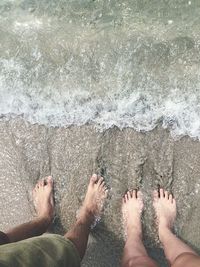 Low section of people standing on beach