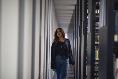 Portrait of a young woman standing in corridor