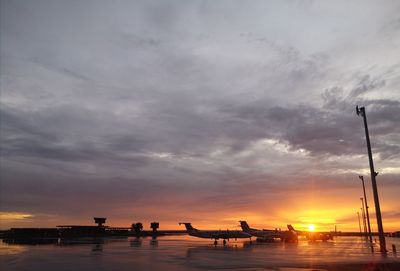 Silhouette aircraft in the sahara desert against sky during sunset