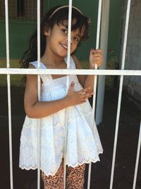 Portrait of smiling girl hanging on metal door