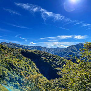 Scenic view of mountains against blue sky