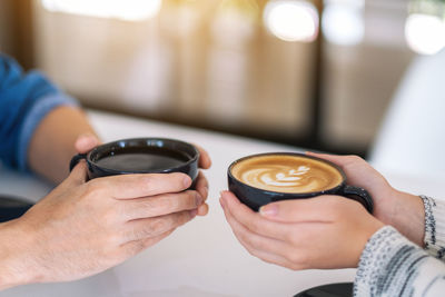 Midsection of woman holding coffee cup