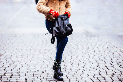 Low section of woman walking on street in winter