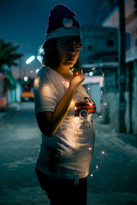 Side view of woman standing against city