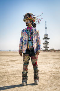 Full length of woman standing on field against clear sky