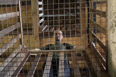 Portrait of man in cage