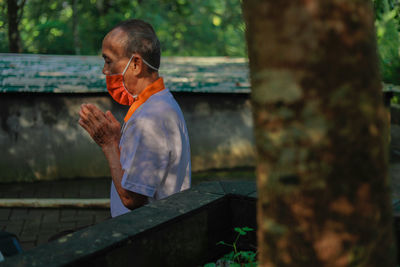 Side view of man standing on wood