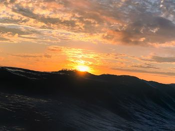 Scenic view of silhouette mountains against sky during sunset