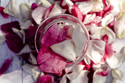 Directly above shot of jar filled with rose petals on table