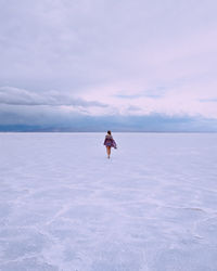 Man in sea against sky during winter