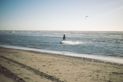 View of calm beach against clear sky