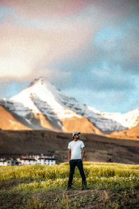 Rear view of man standing on field against sky