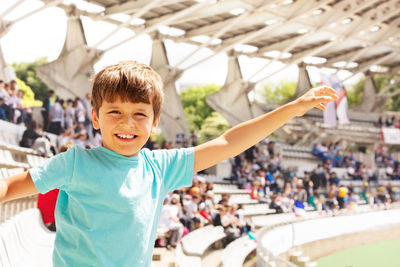 Portrait of boy gesturing at stadium