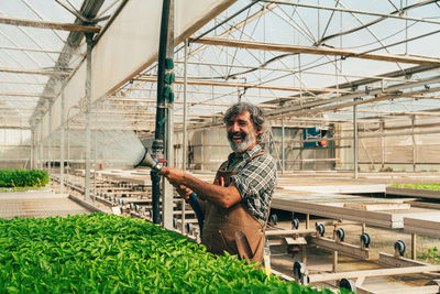 Full length of young man standing in greenhouse