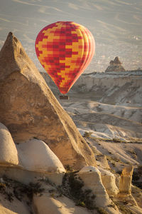 Hot air balloon flying over rocks