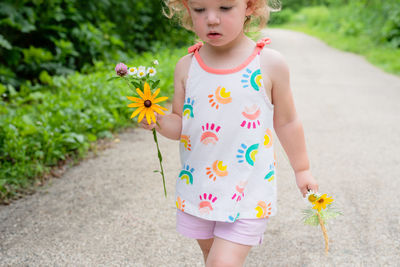 Low section of girl holding flowers