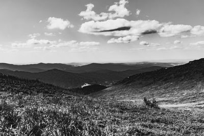 Scenic view of land and mountains against sky