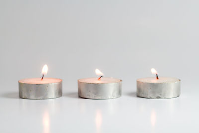 Close-up of burning candle against black background