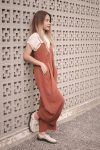 Side view of young woman standing against wall