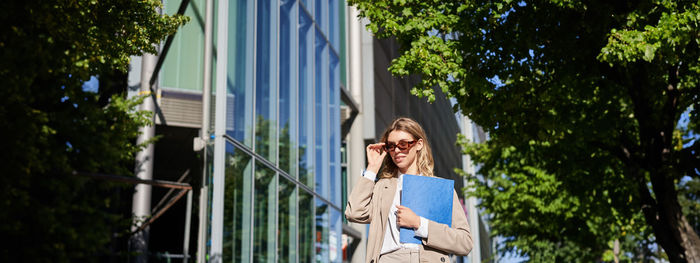 Low angle view of woman holding umbrella