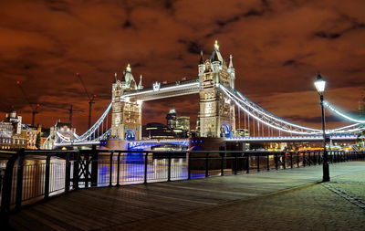 Illuminated bridge over river at night