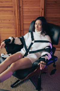 Young woman sitting on sofa at home