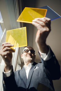 Senior architect standing at window, choosing materials