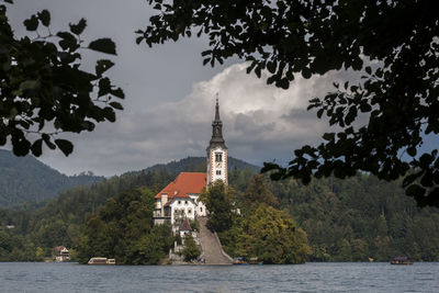 View of island with church amidst trees and plants against sky