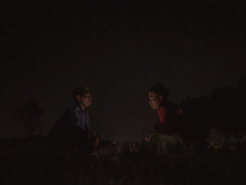 People sitting on land at night