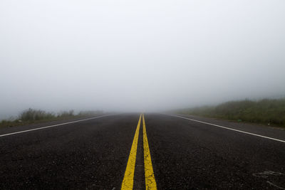 Empty road against sky during foggy weather