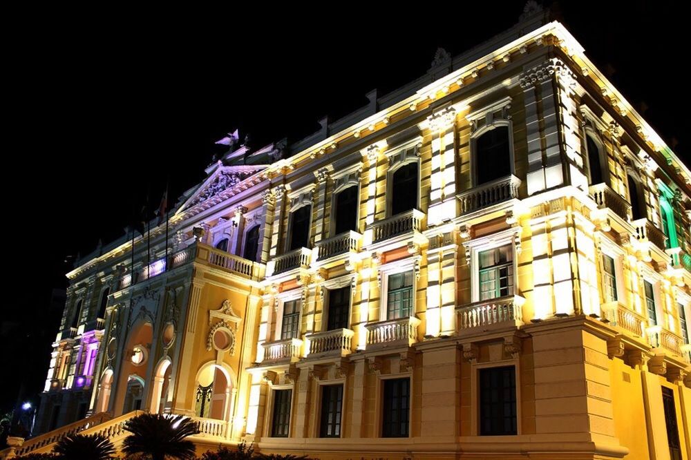 LOW ANGLE VIEW OF ILLUMINATED BUILDING AT NIGHT