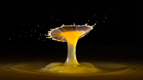 Close-up of yellow splashing water against black background