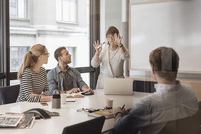 Senior businesswoman giving presentation to colleagues in board room