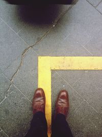 Low section of person standing on tiled floor