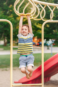 Boy hanging over equipment in playground